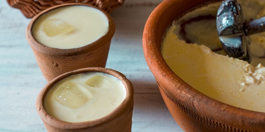 Yogurt-based rich and sweet lassi topped with a dollop of cream served in a clay glass