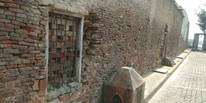 A picture of an ancient temple with traditional brick walls and intricate architecture