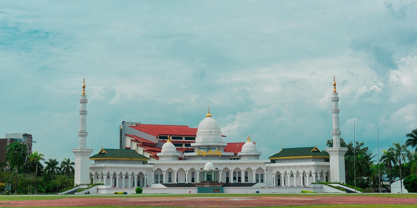 A frontal view of the Kalpeni Juma Mosque in Lakshadweep, surrounded by greenery
