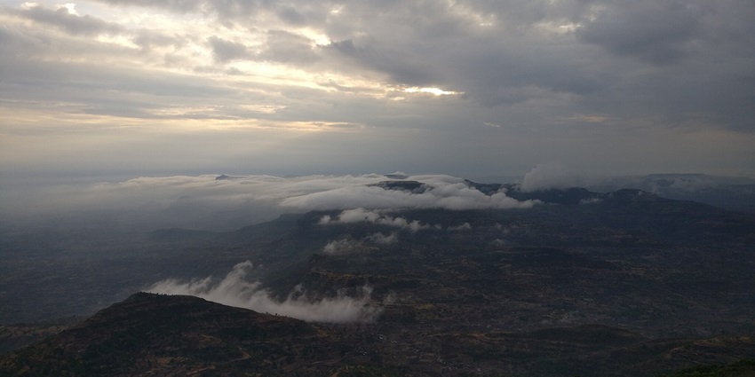 An image of Hikers at the Kalsubai Peak overlooking the scenic Western Ghats.