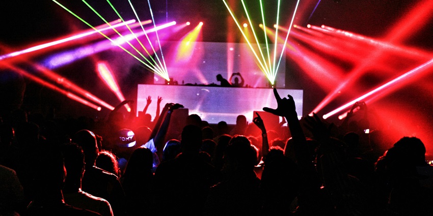 A glimpse of people dancing to the beats synced with dazzling red neon lights.