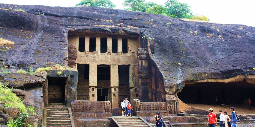 An image of the ancient Kanheri Caves carved into rocky cliffs in Maharashtra, India.