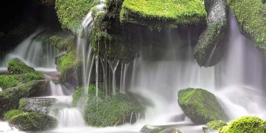 Karanjla Waterfall is a majestic waterfall cascading down rocky cliffs surrounded by green landscapes.