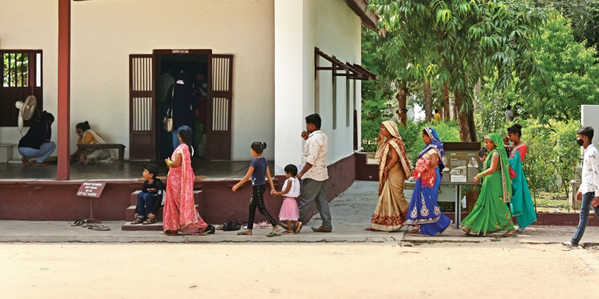 Devotees, including men, women, and children are entering the complex of a temple