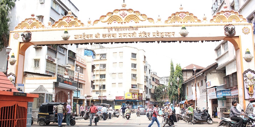 A picture of the entrance gate of a temple in Pune with many devotees entering in line