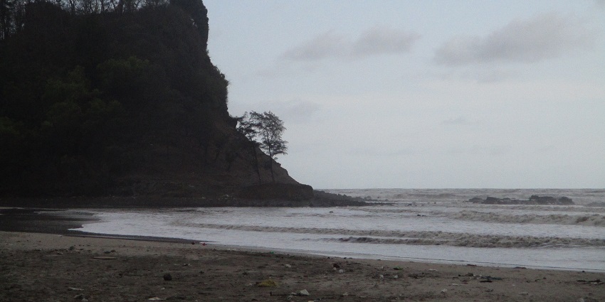 View of the Kashid beach and a tall rocky cliff at the blue hour