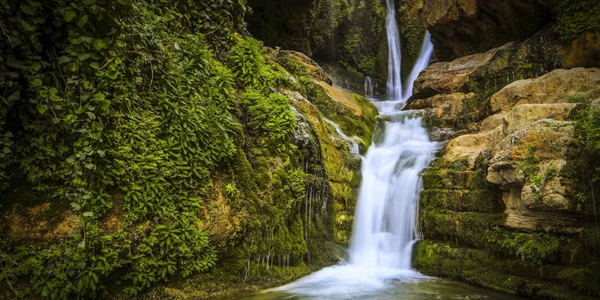 An image of a serene crystal clear waterfall that is resembling the Kaurati Waterfall