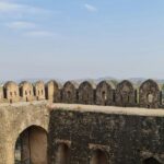 Scenic view of Kavnai Fort surrounded by greenery under a clear blue sky