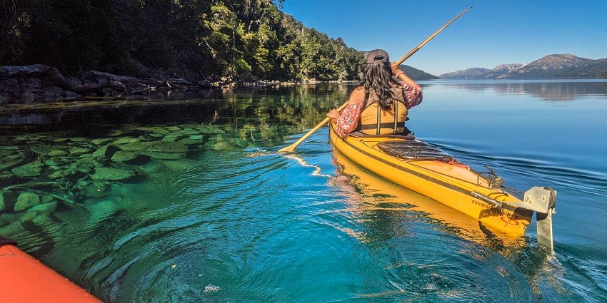 An image of a kayaker paddling and having fun in the calm blue-green waters of Malvan.