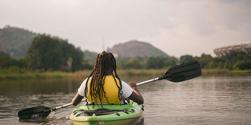 A picture of a solo kayaker paddling peacefully near the coastline of Alibaug Beach.