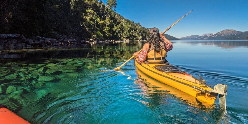 An image of a person kayaking on the calm waters of Lavasa with lush hills in the background.