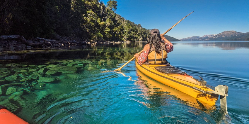 A picture of a woman kayaking through the clear waters of Agatti Island in Lakshadweep