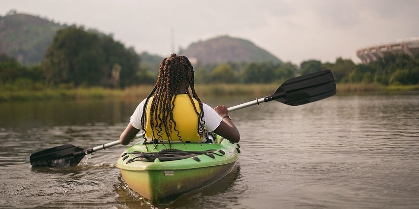 A picture of a kayaker gliding peacefully through the calm waters of Panshet Dam.