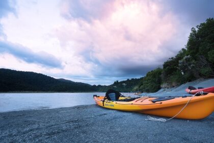 A kayak on the shore of scenic waters of Pune, surrounded by lush hills in Maharashtra