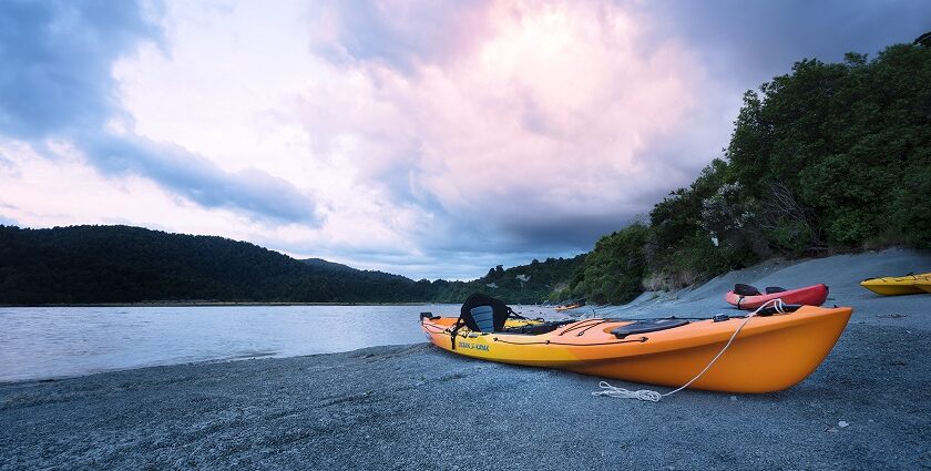 A kayak on the shore of scenic waters of Pune, surrounded by lush hills in Maharashtra