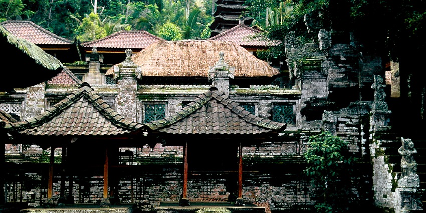 An image showing the stunning tiered shrines of Kehen Temple, surrounded by ancient trees.
