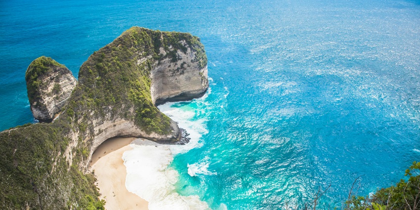 Picturesque view of Kelingking Cliff with stunning coastal views under clear blue sky