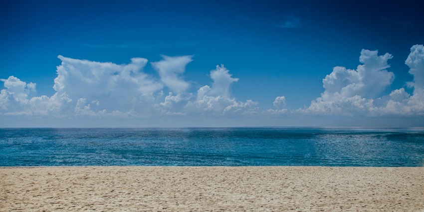 An expansive ocean view with clear blue waters and a bright sky during daylight