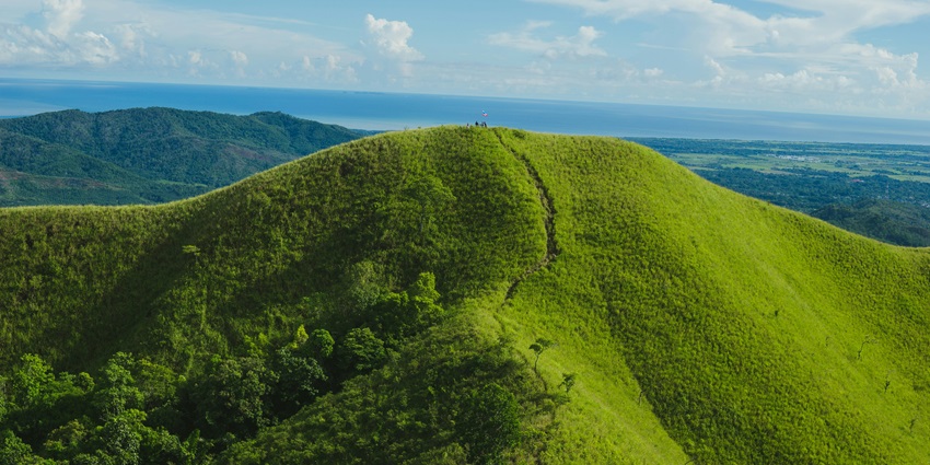 A breathtaking landscape of rolling hills and verdant valleys touching the clear skies.