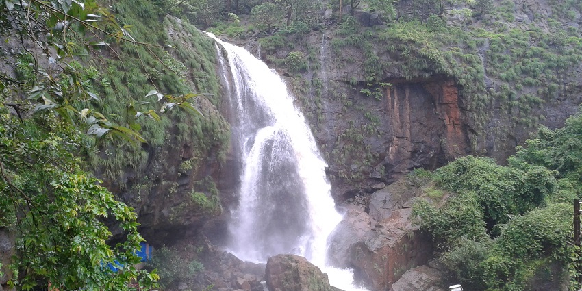 Picturesque waterfall surrounded by greenery, perfect spot for relaxation
