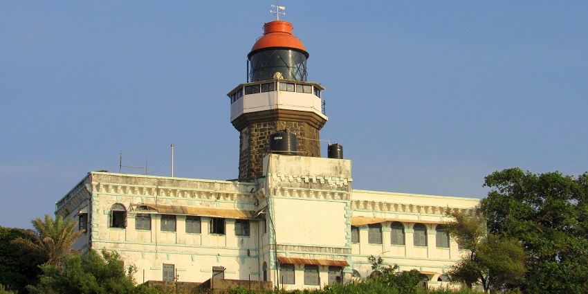 Khanderi Fort lighthouse, a famous place near Sagargad Fort, stands tall on the rocky coastline, surrounded by the sea.