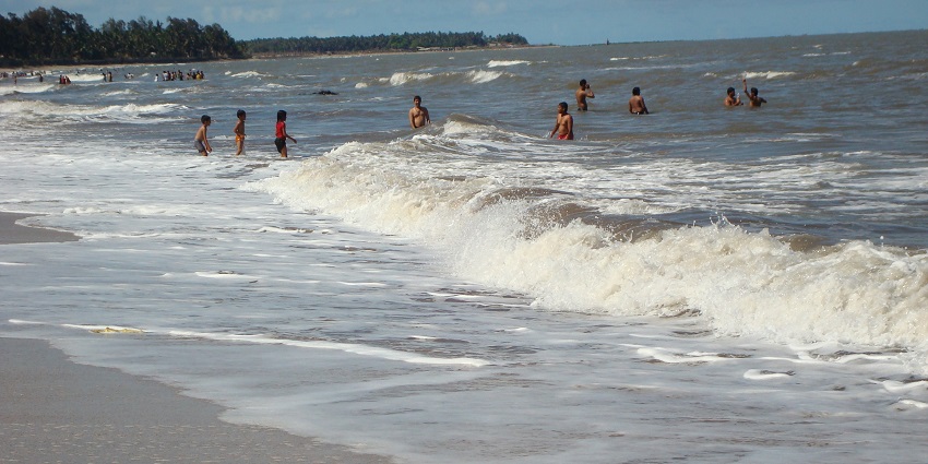 Relaxing view of tourists enjoying the waves on a sunny day on beaches near Mahabaleshwar.