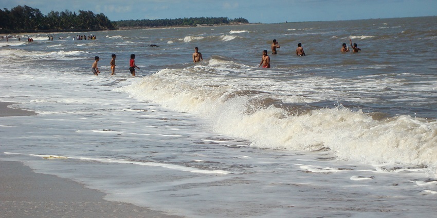 People enjoying the sandy shores and waves at Kihim Beach, offering kayaking in Mumbai.