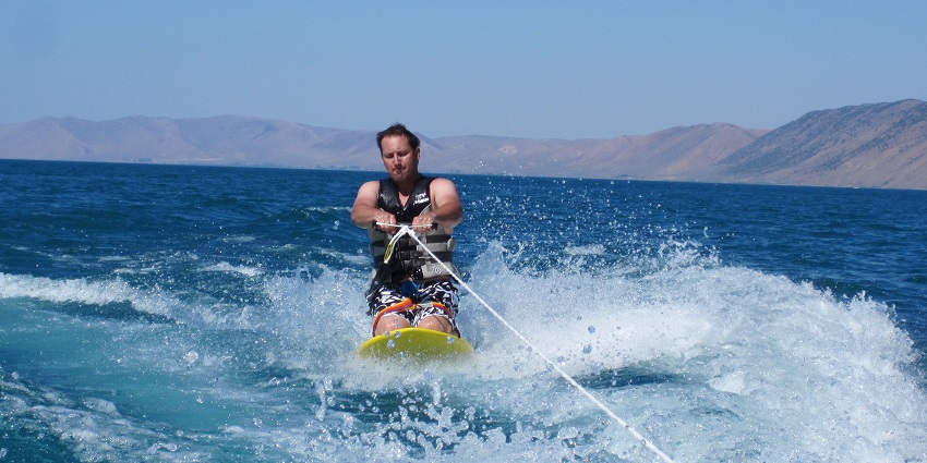 Image of a man kneeboarding in the sea fun for beginners that wants to try this water activity