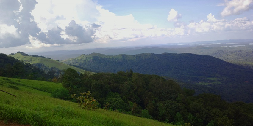 Kodachadri peak with lush green hills and misty clouds in Karnataka's Western Ghats.