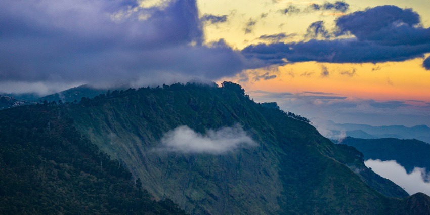 An image of a serene Kodaikanal Lake with a backdrop of hills, surrounded by greenery