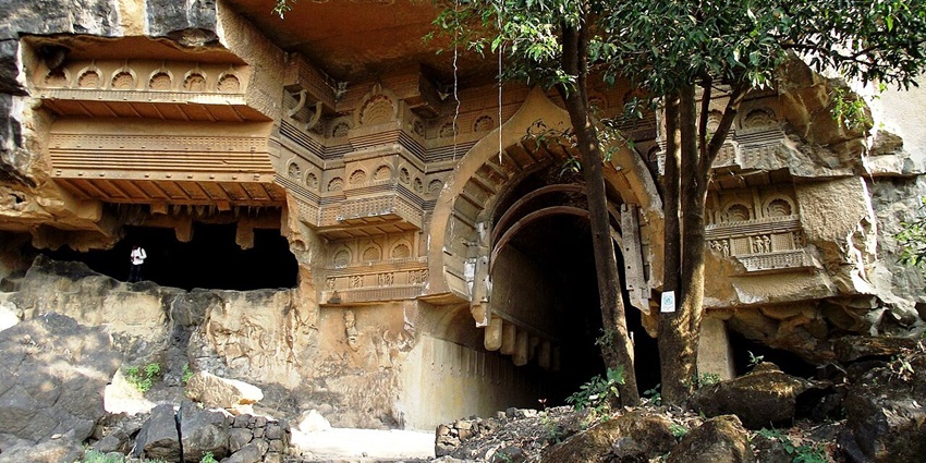 Kondana Caves with rock-cut architecture and greenery surrounding them.