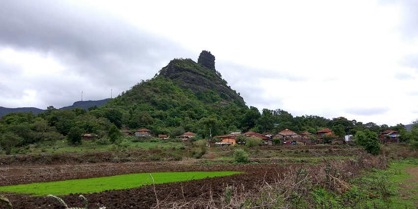 View of Kothaligad Fort, showcasing its ancient architecture against a mountain backdrop.