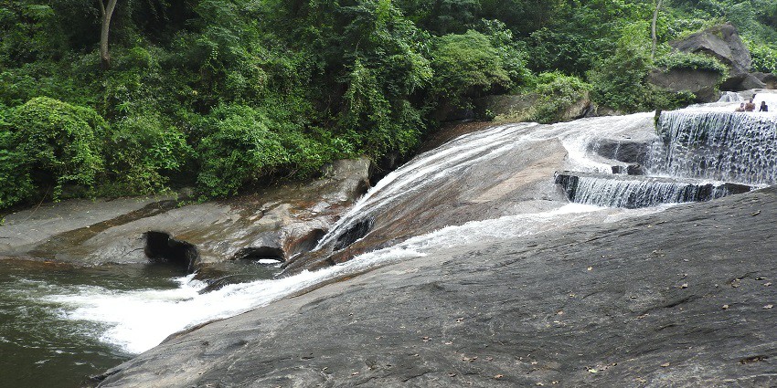 Tourist taking a dip in Kovai Kutralam Waterfall, located near AdiYogi temple.