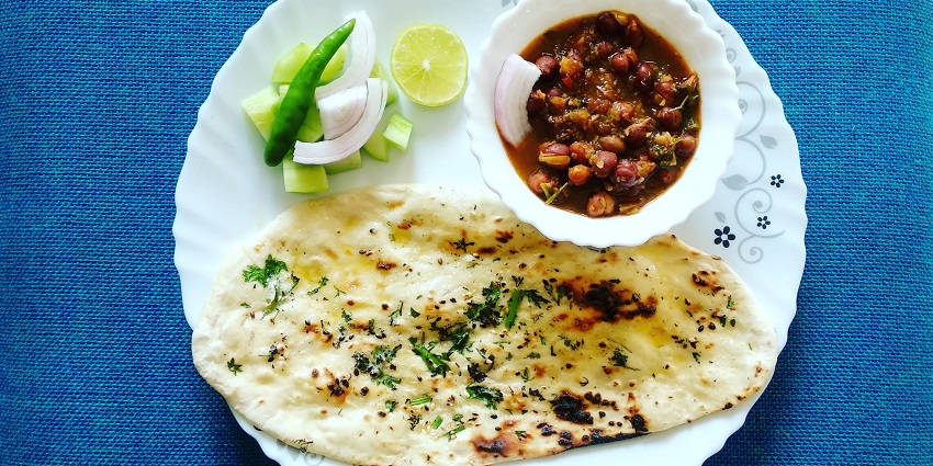 Butter Kulcha served with chole curry and onions, green chilli and lemon