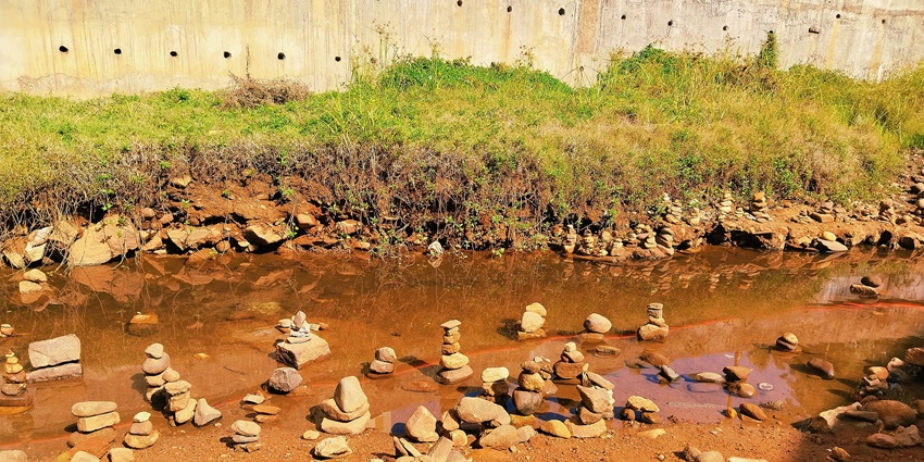 A sacred river flowing through lush forests, where devotees take a holy dip before visiting Kukke Subramanya Temple, one of the best places to visit in Kukke Subramanya.