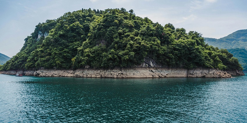 A picture of a verdant island near the Uthirakosamangai temple, surrounded by tranquil waters