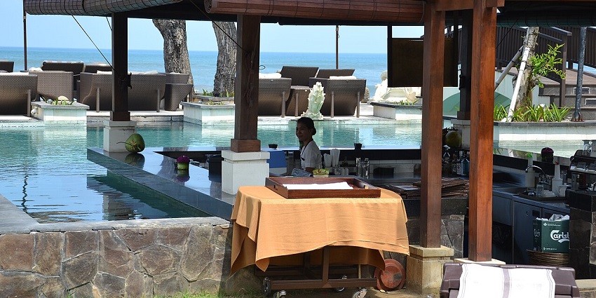 Chic pool bar in Seminyak with stylish seating and refreshing drinks under palm trees