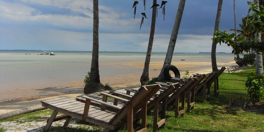 A wide-angle view of Lagoi Bay relaxing lounge chairs on the shores