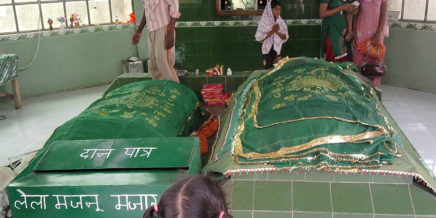 Inside Laila Majnu Ki Mazar in Anupgarh, people praying with a visible donation box.