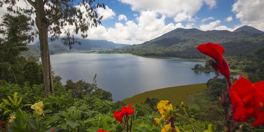 An image of Lake Buyan on Bali Island, Indonesia, surrounded by lush greenery and hills.