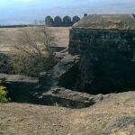 Laling Fort in Dhule district, India, features rugged stone walls and green surrounding hills.