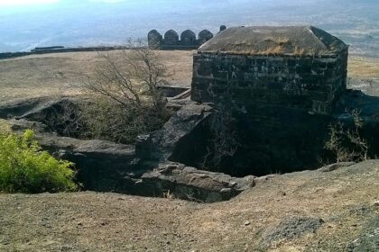 Laling Fort in Dhule district, India, features rugged stone walls and green surrounding hills.