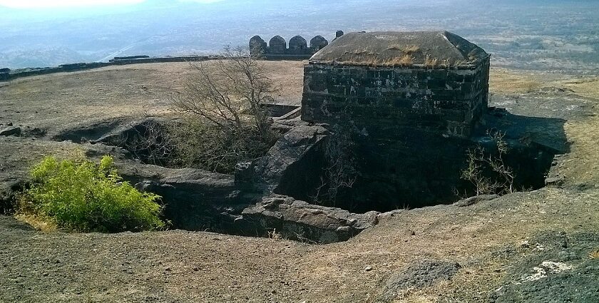 Laling Fort in Dhule district, India, features rugged stone walls and green surrounding hills.