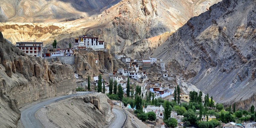 A serene view of pristine white monasteries, rustic terrains, and majestic mountains.