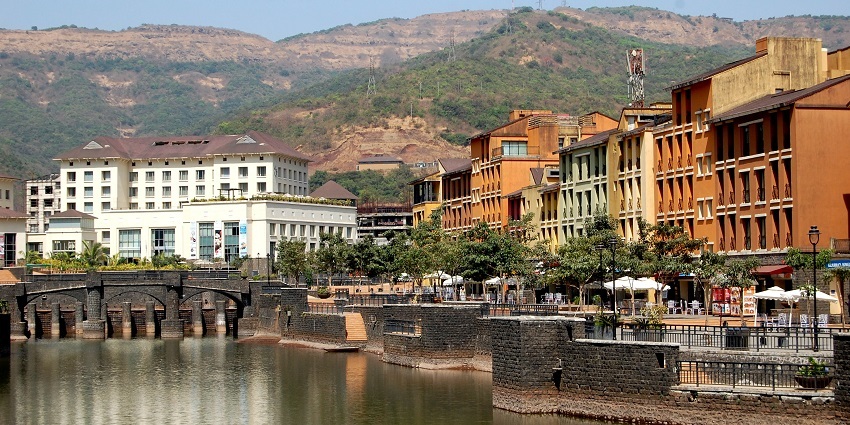 An image of the scenic Lavasa city with colorful buildings nestled amidst lush green hills.
