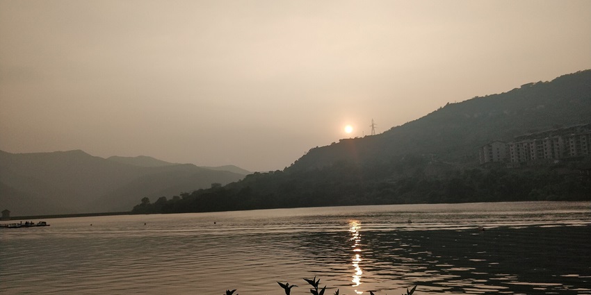 Scenic view of Lavasa's colourful waterfront buildings and lake.