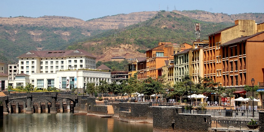 A view of Lavasa City, India, showcasing colourful buildings and surrounding hills