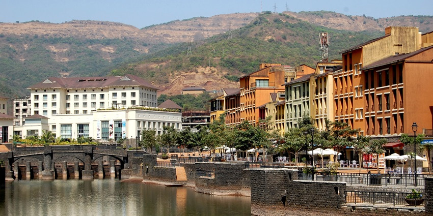 A view of the Lavasa city establishments around a lake with the western ghats in background
