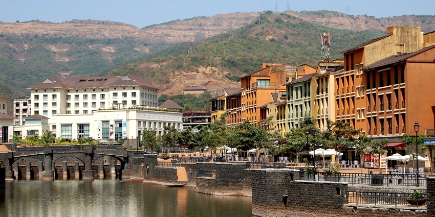 Colorful buildings and lake view of Lavasa City surrounded by green hills–places to visit near pune within 300 km
