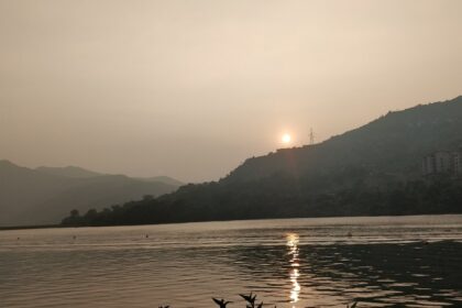 A sunset picture of Lavasa's scenic lake surrounded by lush hills and mountains.